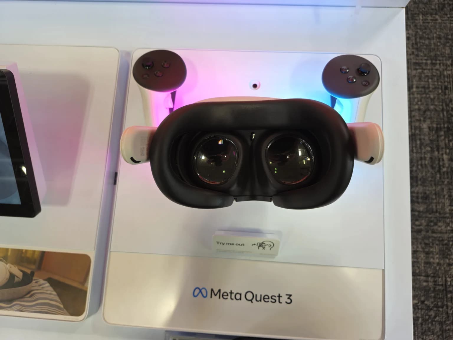 A real Meta Quest 3 headset and controllers displayed at a demo station.