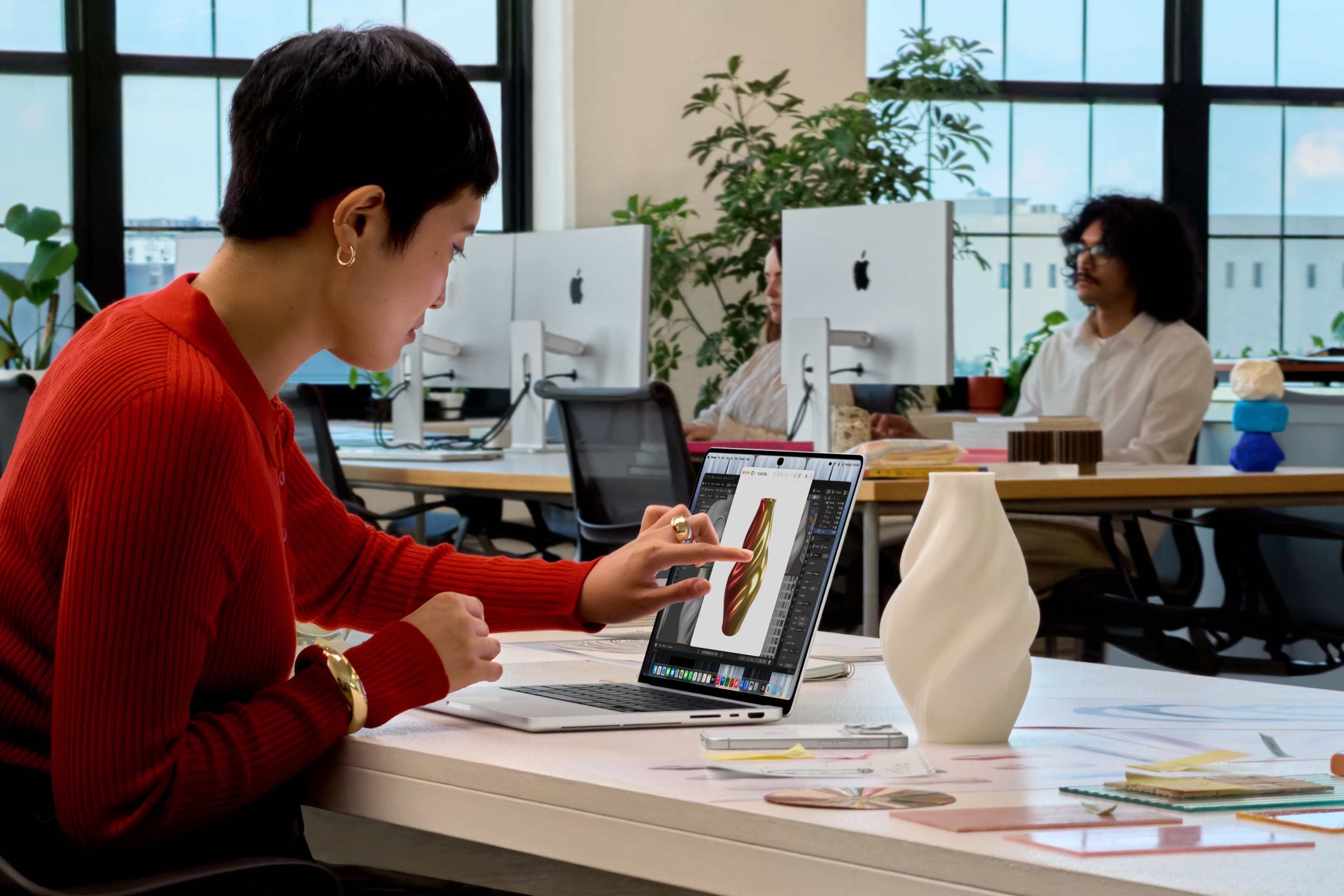Người dùng chạm màn hình MacBook Pro PROLED XDR trong ảnh demo văn phòng chính thức của Apple ngày 28/10/2026