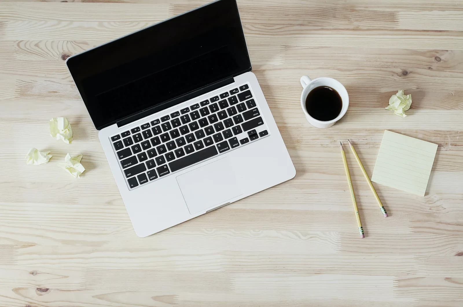 A laptop and coffee on a desk, a real photo illustrating business website preparation.