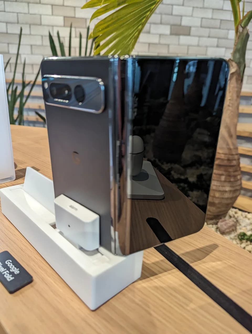 A Google Pixel Fold opened on a retail display with the inner screen visible.